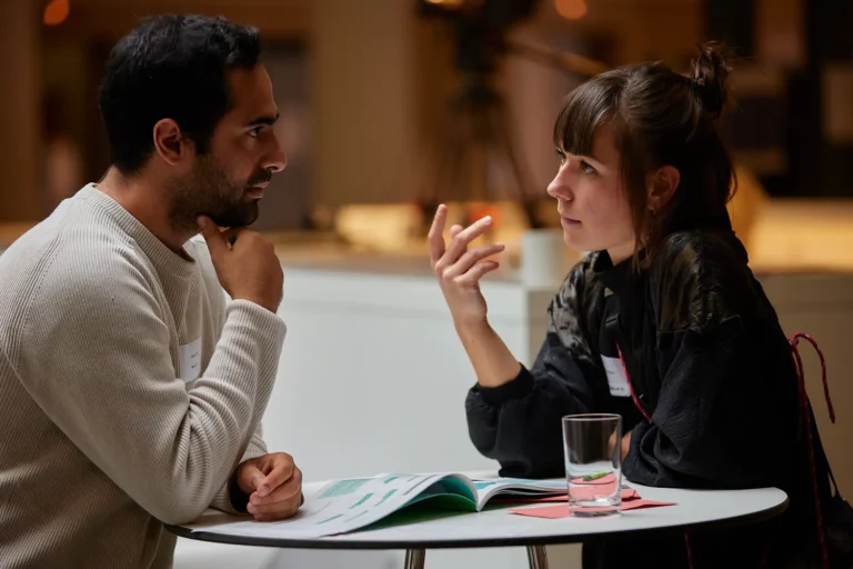 Zwei Menschen an einem Tisch unterhalten sich