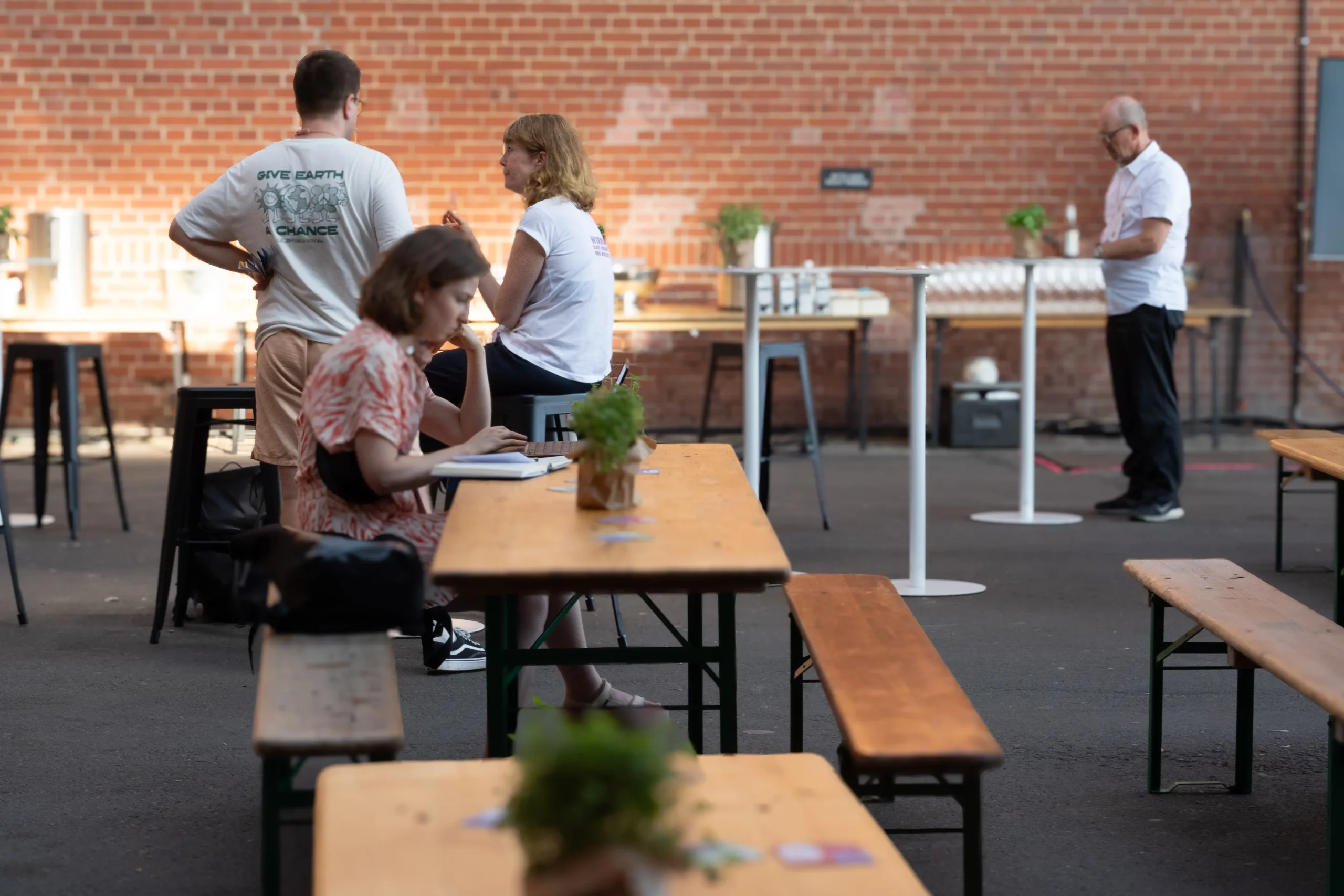 Menschen auf Bierbänken, die arbeiten und sich unterhalten. Konferenz