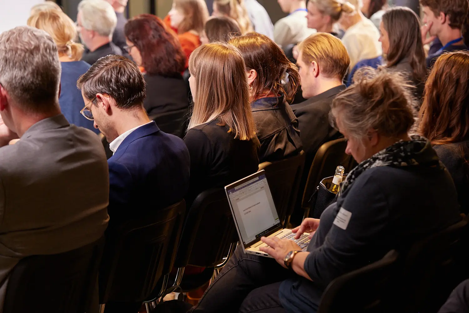 Sitzende Menschen auf einer Konferenz von hinten.